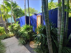 Surrounded by lush tropical plants, this outdoor space offers a serene atmosphere and access to a garden.