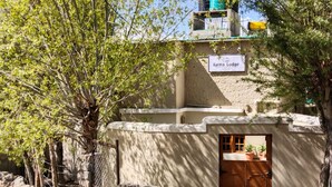 A rustic building with a sign reading "Karma Lodge." - Karma Lodge (Leh)