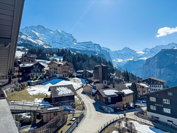 A mountain village with snow-covered buildings and a clear view of the surrounding peaks.