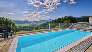A swimming pool with a view of mountains and a fence.