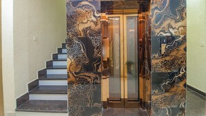 Un intérieur moderne avec un escalier en marbre menant à un ascenseur.