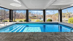 En swimmingpool med utsikt över en sjö och träd.