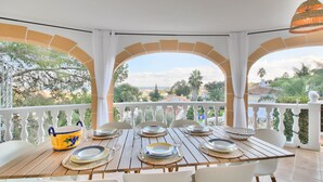 A terrace with a table set for dining, white chairs, and a decorative bowl. - Modern villa with swimming pool and sea views in Denia (Denia)