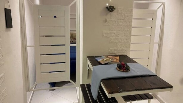 Een kleine kamer met een bed, een tafeltje en een kledingkast.