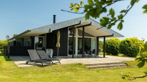 A modern house with a covered patio, a lawn, and a satellite dish. - "Erlinda" - 600m from the sea by Interhome (Humble)