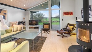 A modern living room with a large TV, comfortable seating, a fireplace, and a view of the outdoors. - "Erlinda" - 600m from the sea by Interhome (Humble)