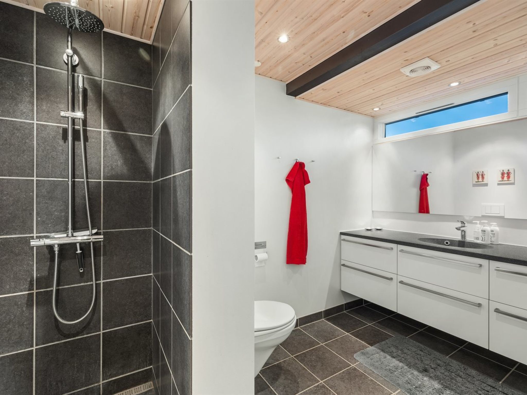 Un baño moderno con ducha, inodoro y lavamanos.