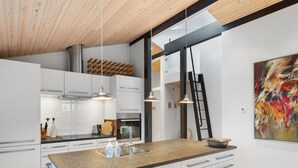 A modern kitchen with white cabinetry, a granite countertop, and stainless steel appliances. - "Erlinda" - 600m from the sea by Interhome (Humble)