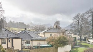 A residential area with houses, a wooden fence, and a grassy yard. - Host Stay Trinity Way (Keswick)