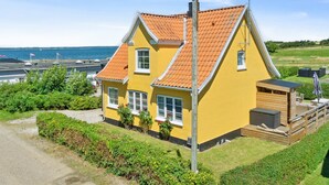 A yellow house with a red-tiled roof, a small deck, and a view of the sea. - "Mari" - 150m from the sea by Interhome (Tranekær)