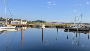 A marina with boats docked, a building with a sign, and calm water reflecting the surroundings. - "Mari" - 150m from the sea by Interhome (Tranekær)