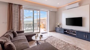 A modern living room with a sofa, coffee table, and a flat-screen TV. - Magnifica Gozitan Villa Pool And Jacuzzi (Xaghra)