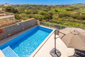 A swimming pool with a view of a hilly landscape. - Magnifica Gozitan Villa Pool And Jacuzzi (Xaghra)