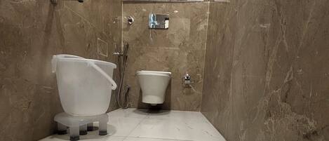 Un baño con inodoro, bidé y ducha.