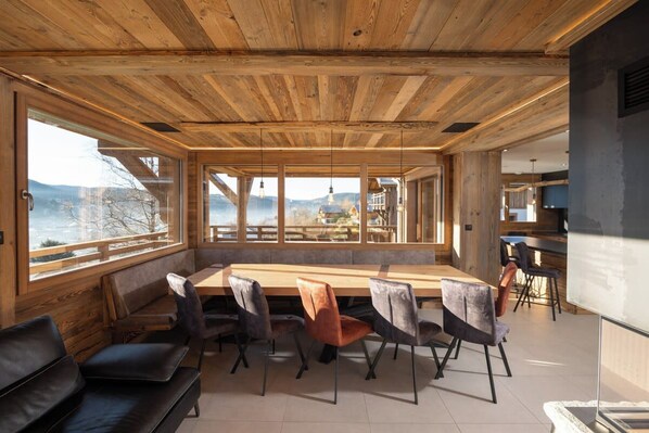 A modern interior with a wooden ceiling, a long dining table, and seating.