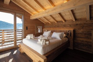 Un dormitorio de cabaña de madera con una cama, almohadas y toallas.
