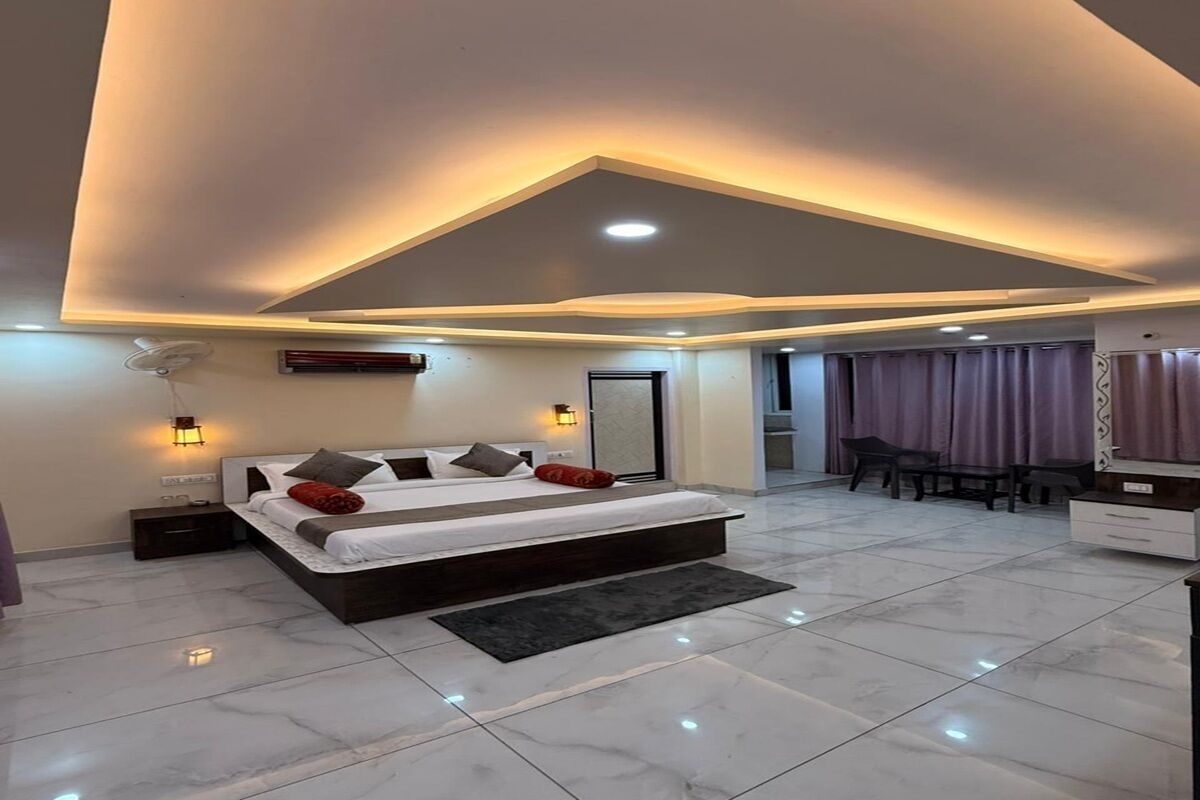 A modern bedroom with a large bed, bedside lamps, and a ceiling fan.