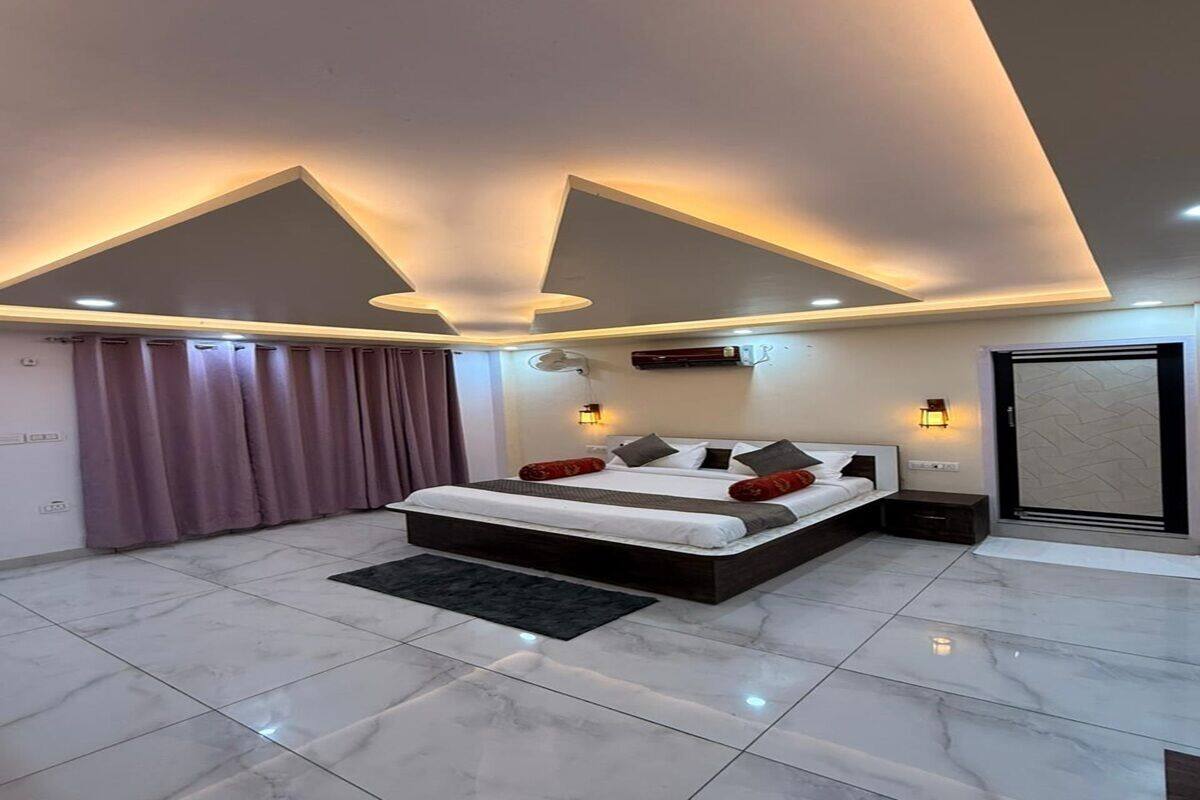 Ein modernes Schlafzimmer mit einem großen Bett, eingelassener Beleuchtung und einem Marmorboden.