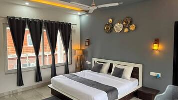 Un dormitorio moderno con una cama grande, un ventilador de techo y vistas a la ciudad desde la ventana.