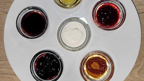 A white plate with six small glass containers of different sauces. - The RISE (Tashkent)
