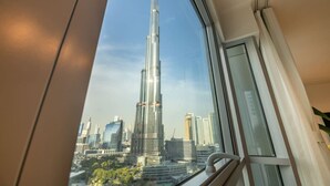 A view of the Burj Khalifa from inside a building, looking out through a window.