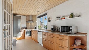 Uma cozinha moderna com armários de madeira, micro-ondas e máquina de café.