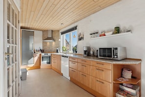Una cocina moderna con armarios de madera, un microondas y una cafetera.