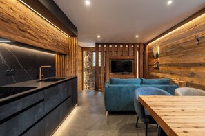 Une cuisine moderne avec un plan de travail noir et un lambris en bois.
