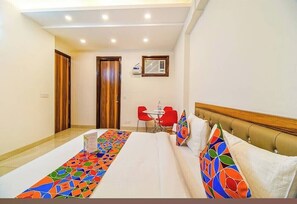 Relax in this stylish room with a large bed, two comfortable chairs, and a small table for dining or working.