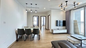 Una sala de estar moderna con comedor, un sofá, un televisor y un balcón.