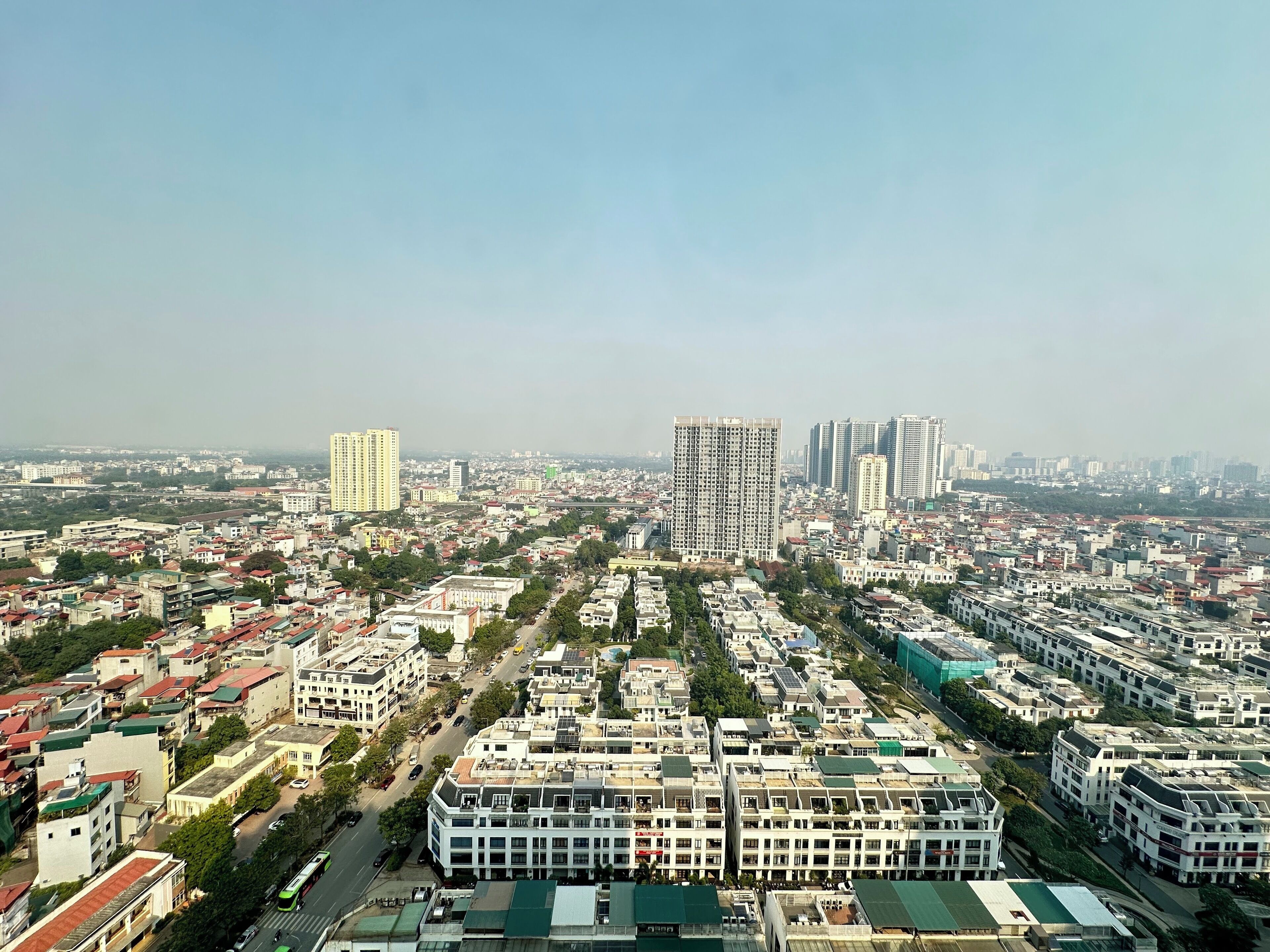 A cityscape with high-rise buildings, a dense residential area, and a prominent road intersection.