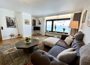 A modern living room with a sofa, coffee table, and a TV. - Holiday Home with Garden, Terrace and Wi-Fi (Sundern)