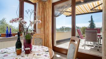 A balcony with a table, chairs, and a view of the landscape.