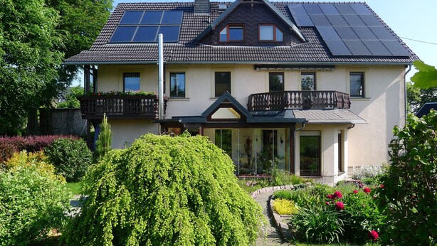 A two-story house with a balcony, solar panels, and a garden. - Apartment 'Börner' with Mountain View and Wi-Fi (Frauenstein)