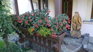 A garden with a wooden bench, a statue, and a stone pathway. - Apartment 'Börner' with Mountain View and Wi-Fi (Frauenstein)