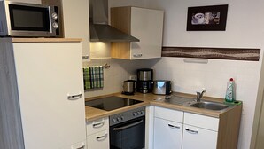 A compact kitchen with a microwave, coffee maker, toaster, and oven. - Holiday Apartment 'Braun' with Mountain View and Wi-Fi (Lindau)