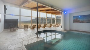 A swimming pool with a stone floor, wooden ceiling beams, and a view of the outdoors. - Apartment 'Ostseeblick Fewo 6' with Private Terrace, Balcony and Wi-Fi (Kronsgaard)