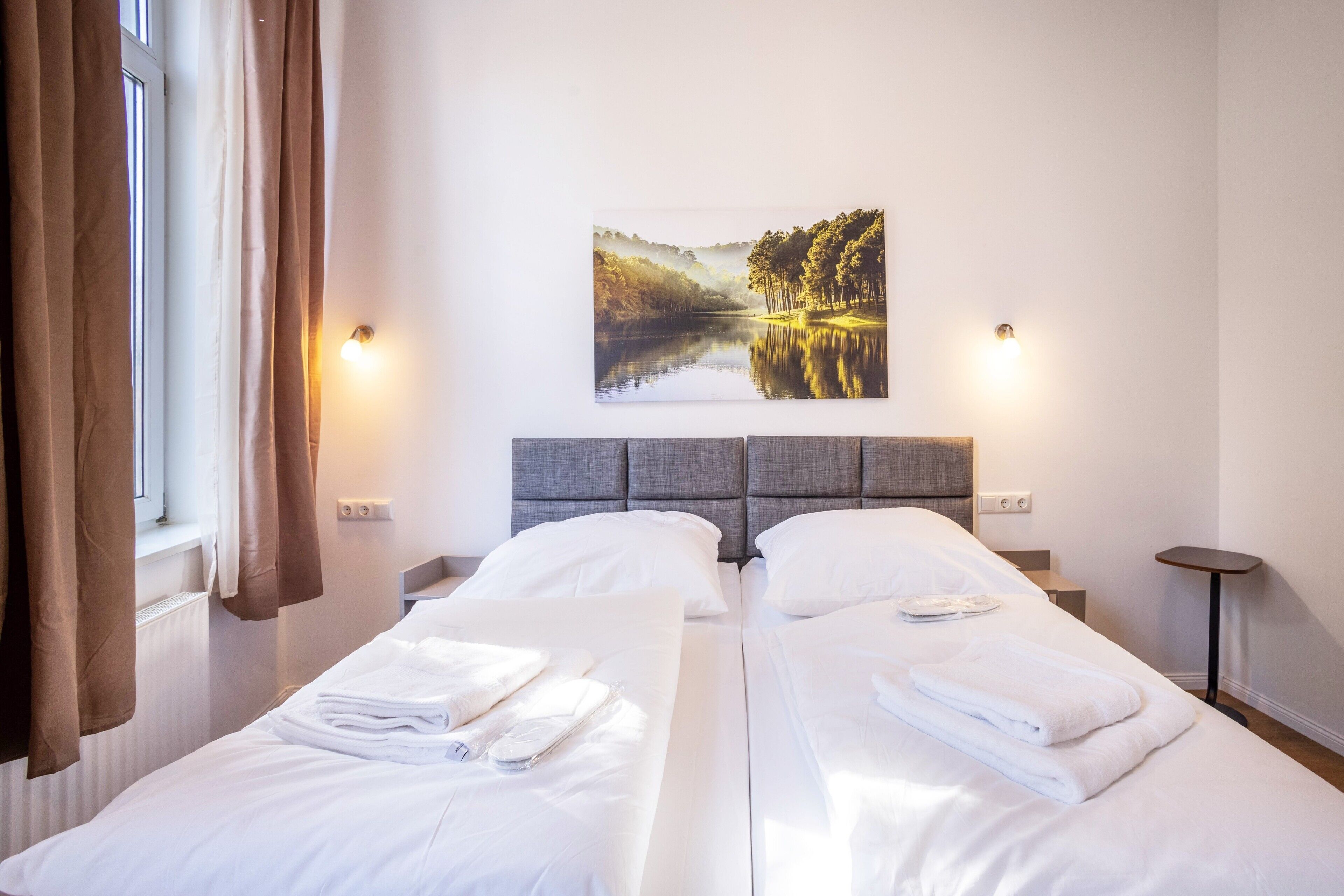 Ein Hotelzimmer mit zwei Betten, Seeblick und einem Bild an der Wand.