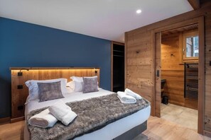 Relax in this serene bedroom with a large bed and a closet.
