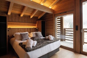 A wooden cabin bedroom with a bed, pillows, and a fur throw.