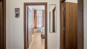 A hallway with wooden doors, a mirror, and a framed picture on the wall. - 2-room apartment 2-2 with balcony and Wi-Fi (Lübeck)