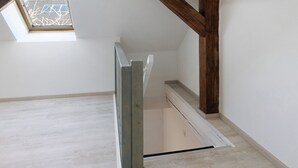 A staircase with a wooden handrail, white walls, and a skylight. - Holiday Home 'Ferienhaus' with Private Terrace, Private Garden and Wi-Fi (Zernitz-Lohm)