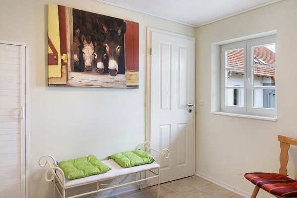 A room with a bench, a door, and a window.