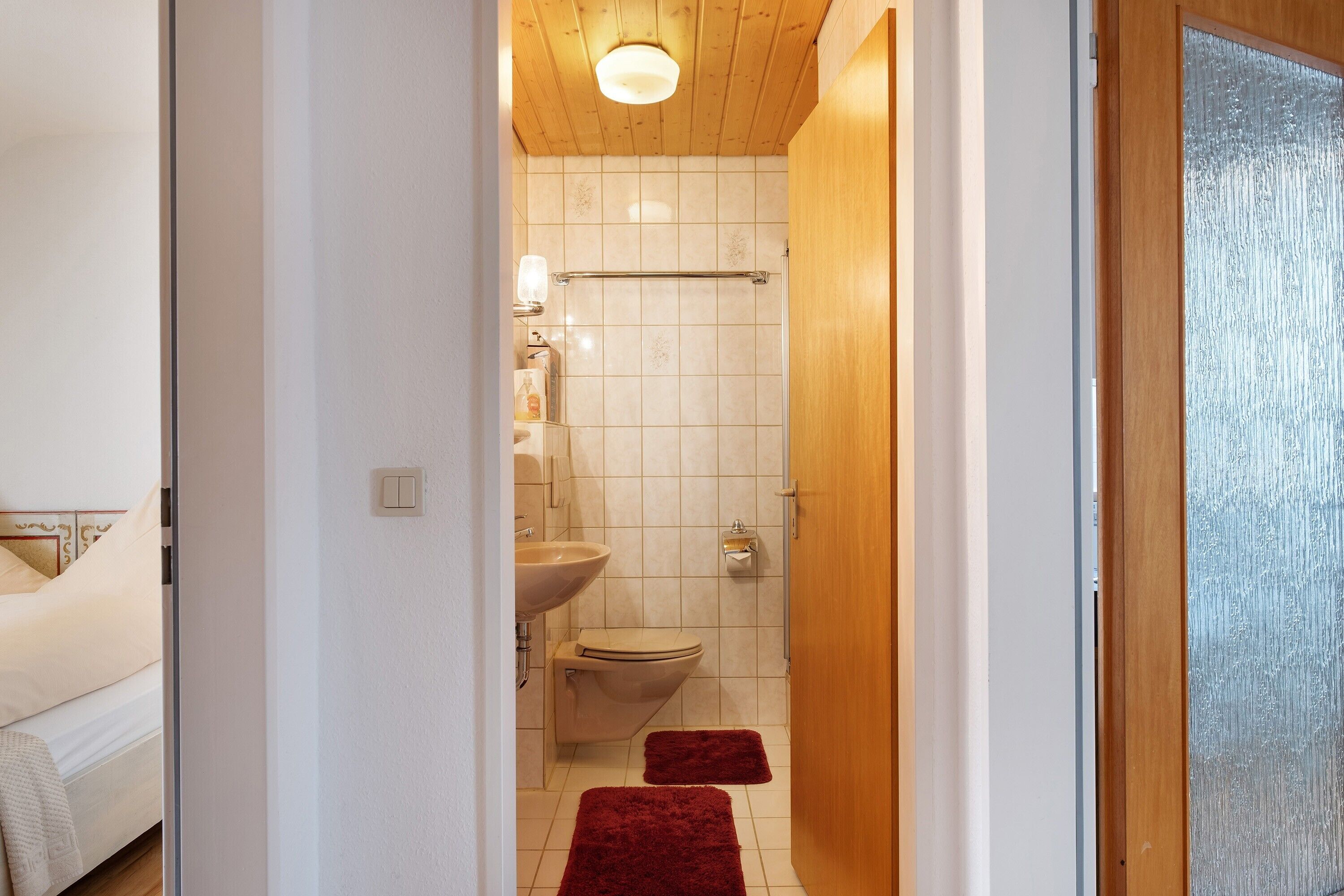 Une salle de bain avec des toilettes, un lavabo et une douche.