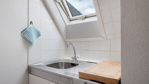 A kitchen with a window, a sink, and a cutting board. - Holiday Apartment '2' with Mountain View, Shared Garden and Wi-Fi (Hinterzarten)
