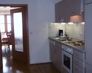 A kitchen with a coffee maker, sink, oven, and cabinets.