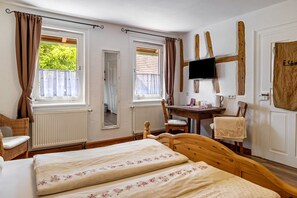 A room with two beds, a desk, a chair, a television, and a window with curtains. - Room 'Hofblick' with Shared Garden and Wi-Fi (Rosenfeld)