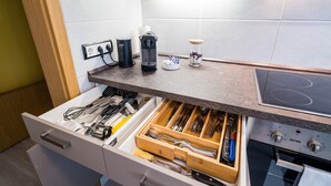 Eine Küche mit Schubladeneinsatz, der Besteck, eine Kaffeemaschine und ein Glas auf der Arbeitsfläche enthält.
