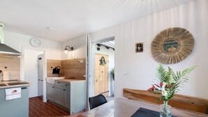 Une cuisine moderne avec un îlot central en bois, un coin repas avec un banc et un miroir fixé au mur.