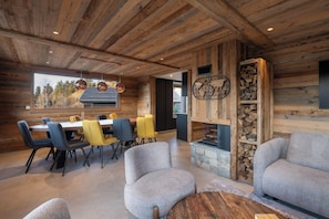 Ein rustikales Interieur mit Essbereich, Sofas und Kamin.